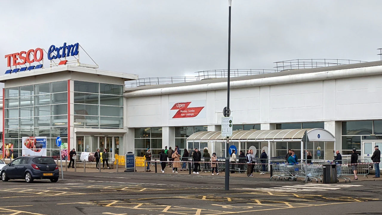 A local supermarket has set up a queue with barriers, and is counting the number of people in and out of the store.