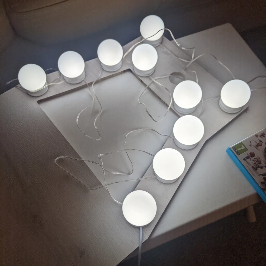 This was an attempt to make a cheap lighting and camera rig. The idea was that the mobile phone would lie on top with the camera positioned over the hole. The lights would illuminate the work area. Unfortunately, due to the number of reflective surfaces and the low brightness of the bulbs, this approach didn't work out.