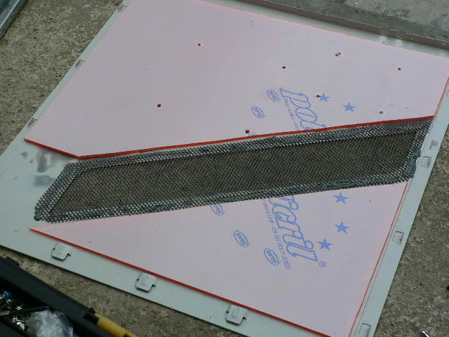 Side-panel mesh being fixed into place with liquid metal. You can also see here that the fan screw holes have been drilled into the perspex.